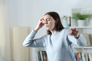 Woman trying to keep her balance after feeling dizzy. 