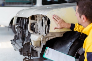 A man examining a damaged car.