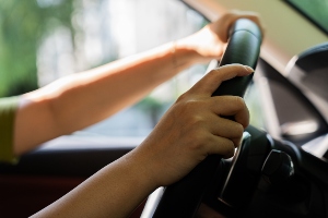 Someone's hands on a steering wheel. 