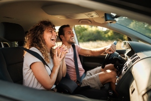 Two people laughing in a car.