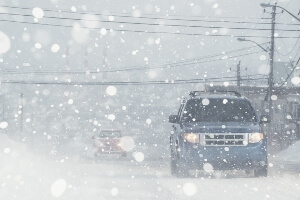 image of an SUV driving through a white-out snow storm