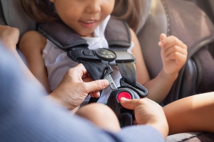 A child being secured in a car seat.